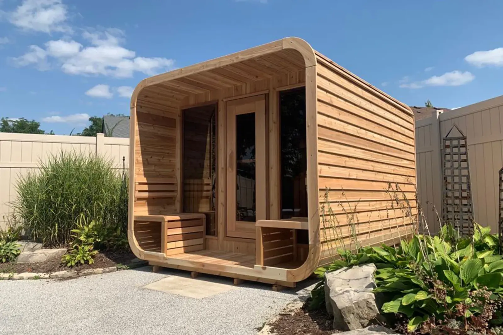 A Red Cedar knotty outdoor sauna in a garden setting – available at Carr Bank Garden Centre, Cumbria. Red Cedar knotty outdoor sauna exterior garden view – luxury garden sauna from Carr Bank Garden Centre Cumbria