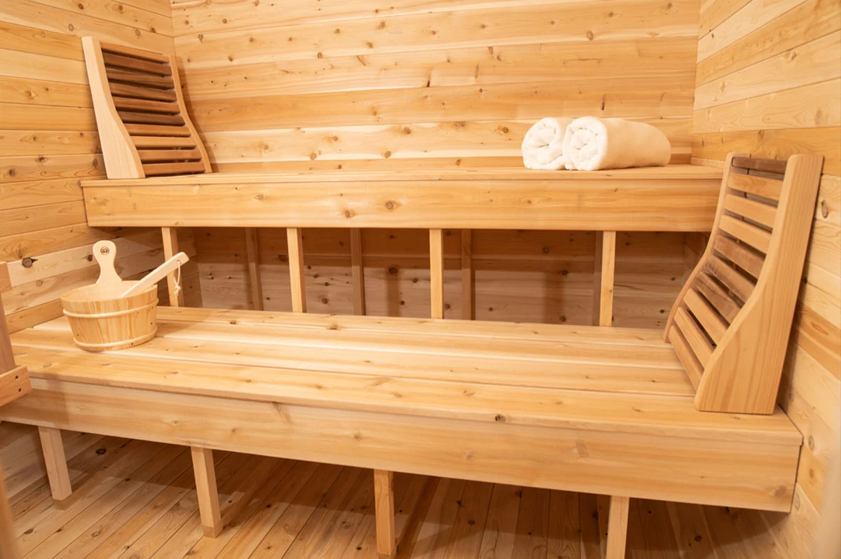 Interior of the Luna White Cedar Outdoor Sauna showing tiered bench layout and open front – at Carr Bank Garden Centre. Luna White Cedar Outdoor Sauna interior tiered benches open front – sauna from Carr Bank Garden Centre