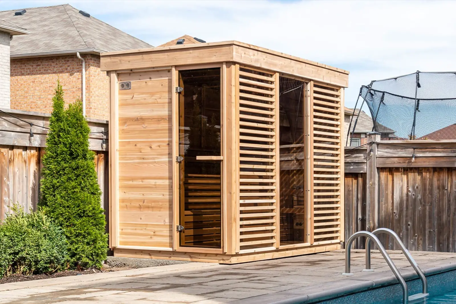 The Pure Cube Sauna in Red Cedar knotty finish, installed in a garden – available at Carr Bank Garden Centre. Pure Cube Sauna Red Cedar knotty exterior in garden – outdoor cube sauna from Carr Bank Garden Centre